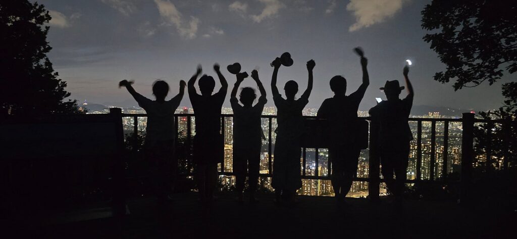 대모산 구룡산 정상 야간맨발걷기를 진행한 맨발벗이 서울 야경을 향해 머리위손을 올리고 두팔벌려 기념촬영을 하고 있습니다.