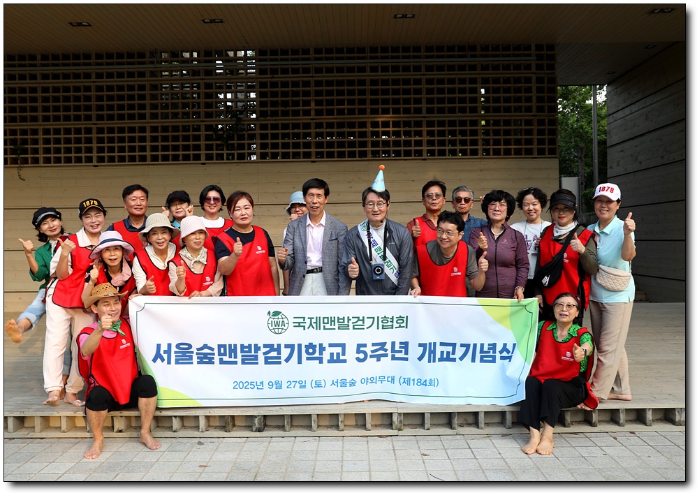 국제맨발걷기협회가 주최한 서울숲맨발걷기학교 개교5주년, 참가자들이 야외무대에서 현수막을 들고 함께 기념 촬영을 하며 건강한 맨발걷기와 K-어싱 문화를 알리는 모습