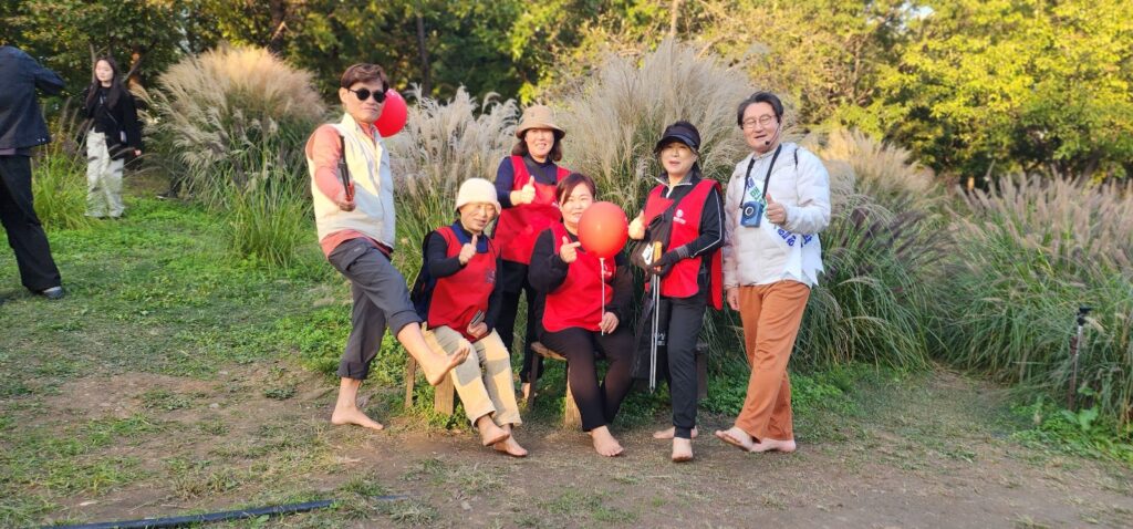 서울숲맨발걷기학교에서 10여명의 회원들이 플로깅 자원봉사자들이 활동을 하고 일어서서 활짝웃으며 서있습니다. 자원봉사 플로깅 1365 인증